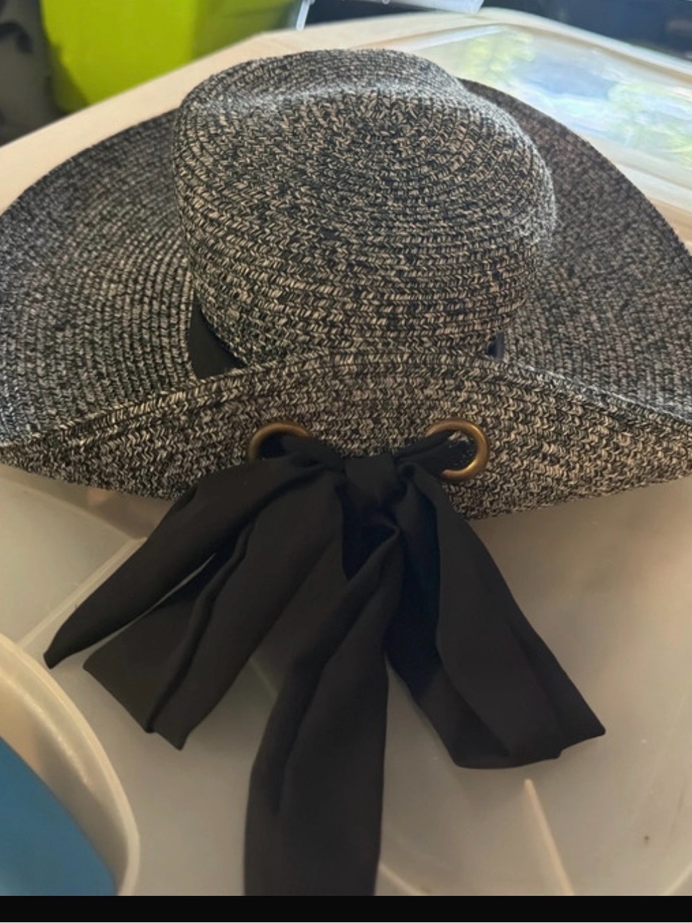 black and white woven straw sun hat features a large brim and a black bow detail